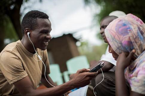 young africans listening to radio on a mobile device with earpieces